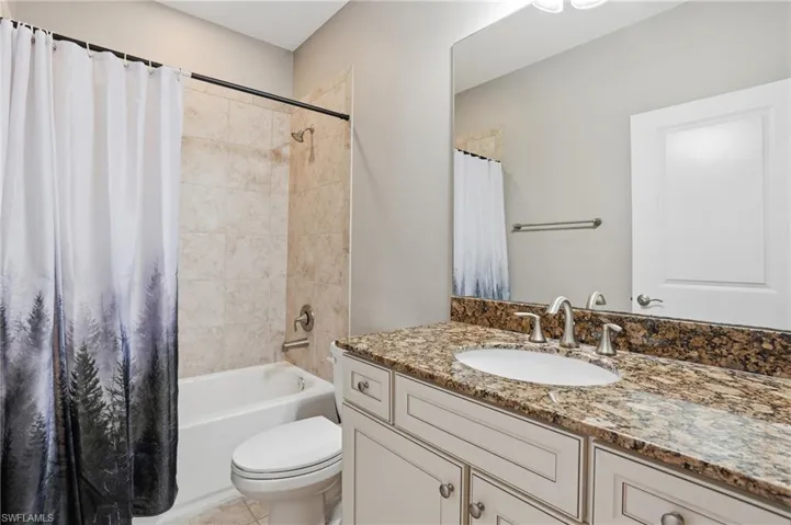Bathroom with shower / tub combo with curtain and vanity