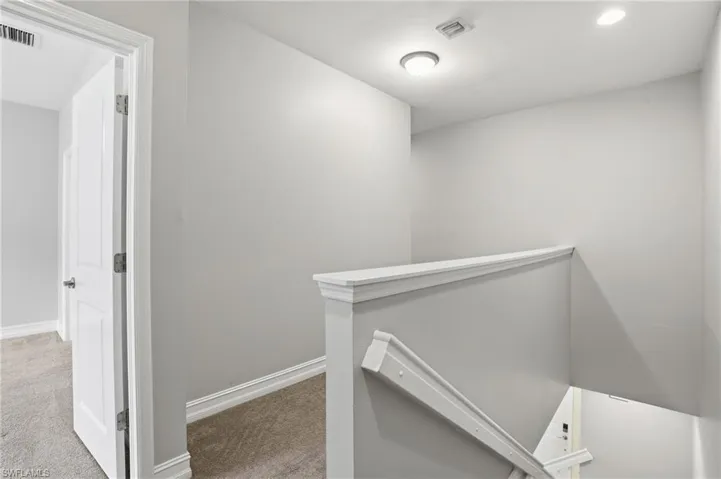 Corridor featuring an upstairs landing, light colored carpet, and recessed lighting