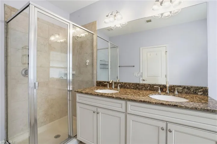 Bathroom with double vanity and a stall shower