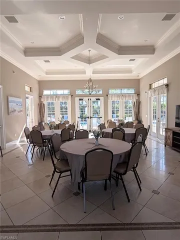 Dining area featuring french doors, light tile patterned floors, plenty of natural light, coffered ceiling, and beamed ceiling
