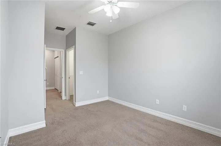 Unfurnished bedroom with light carpet and ceiling fan