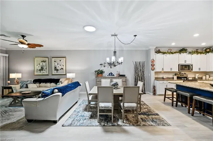 Dining area featuring crown molding and ceiling fan with notable chandelier