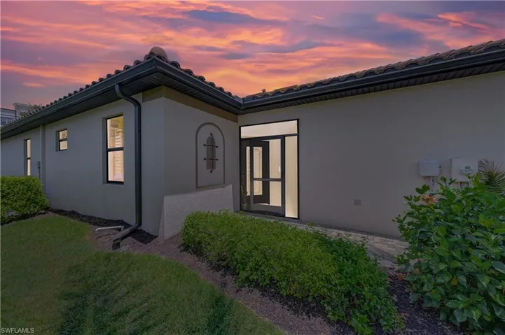 Exterior entry at dusk featuring a yard