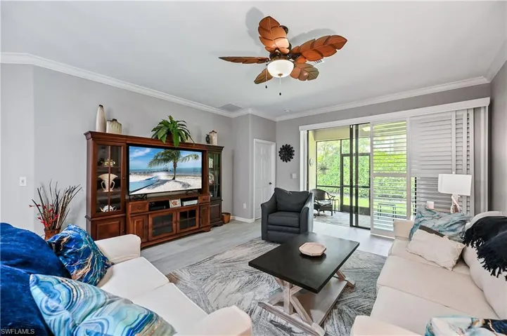 Living room featuring ceiling fan, crown molding, and light wood-type flooring