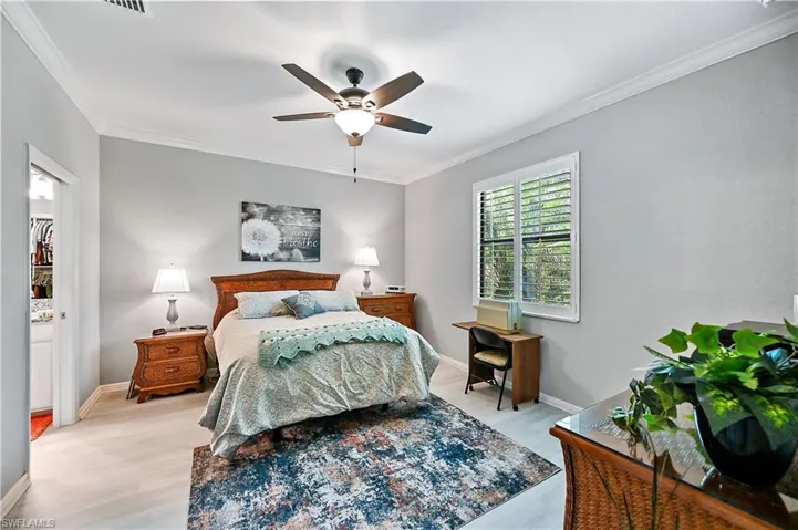 Bedroom featuring ceiling fan, light hardwood / wood-style floors, and ornamental molding