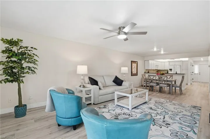 Living area with light wood-style floors and a ceiling fan