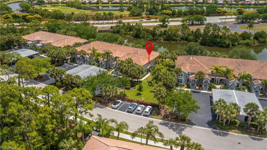 Aerial view of a residential complex featuring tile roofs and mature landscaping