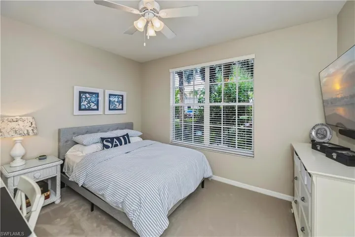 Carpeted room featuring a window with blinds, a ceiling fan, and neutral wall tones