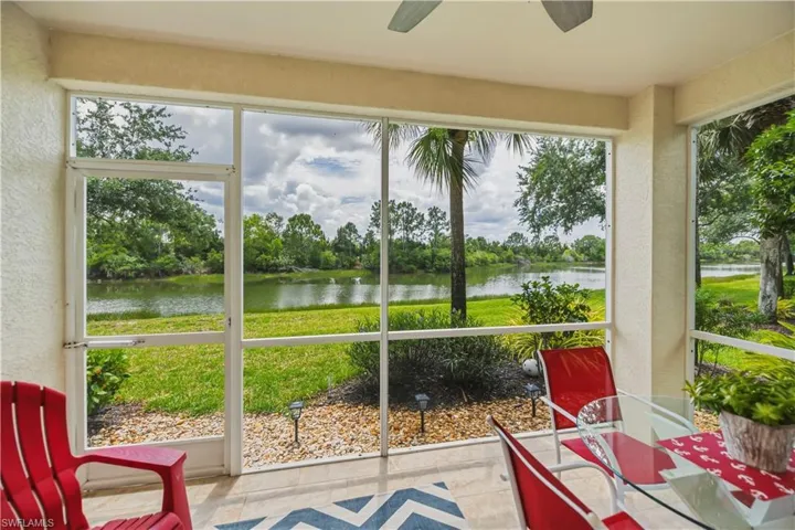 Screened lanai featuring a ceiling fan, tiled flooring, and expansive water frontage