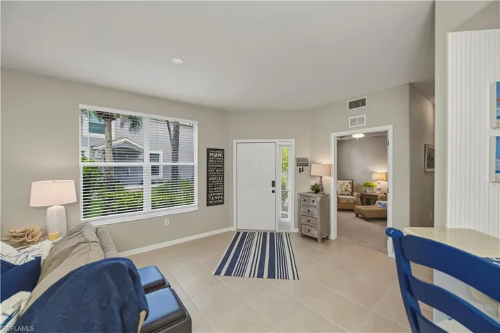 Bright living space featuring light neutral wall tones and tile flooring