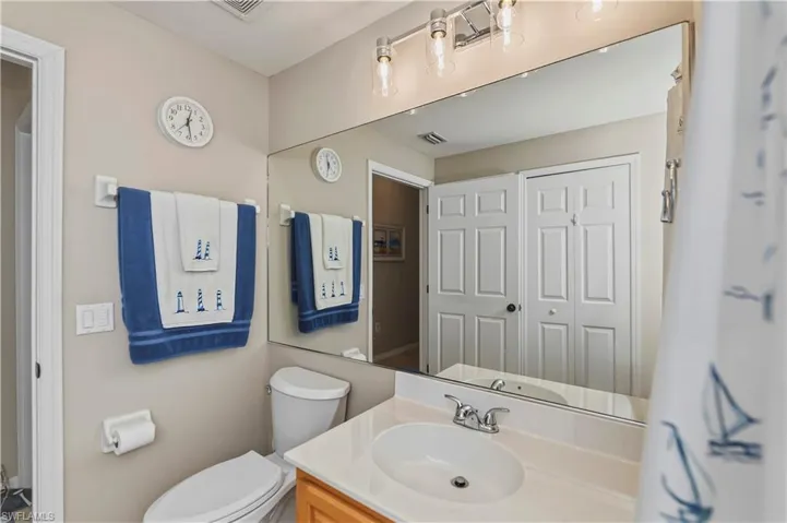 Bathroom vanity featuring a light-colored countertop, undermount sink, and chrome faucet