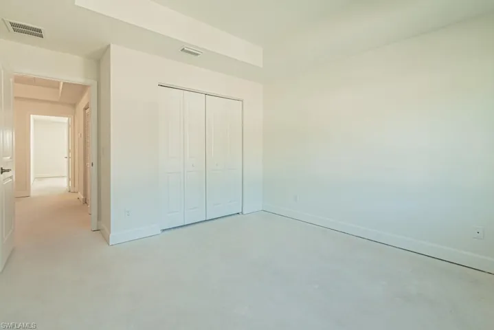 Unfurnished bedroom featuring finished concrete floors and a closet