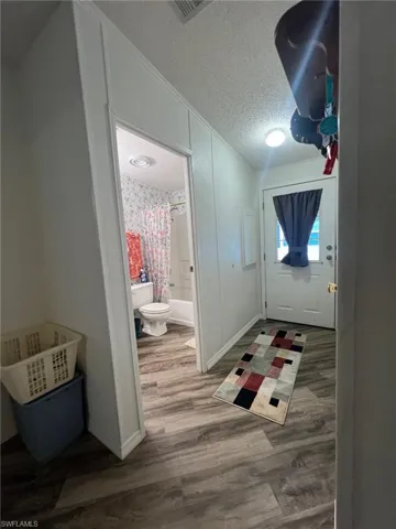 Doorway to outside with hardwood / wood-style floors and a textured ceiling
