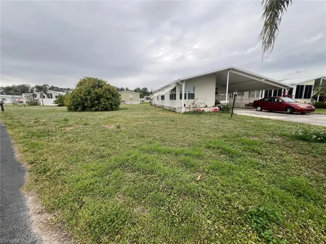 View of side of property featuring a yard and a carport
