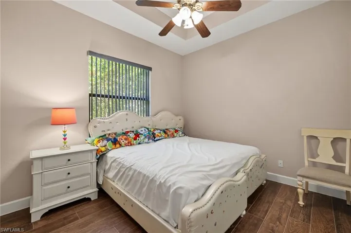 Bedroom with dark hardwood / wood-style floors and ceiling fan
