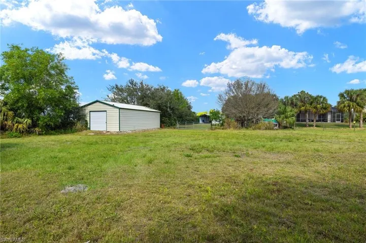 View of yard with a garage and an outdoor structure