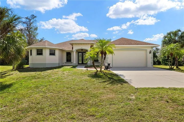 Mediterranean / spanish-style house with a garage, a front yard, and french doors