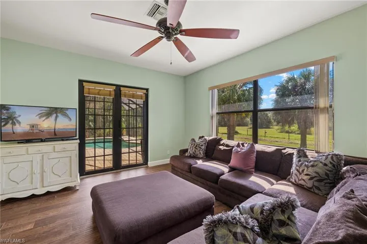 Living room with french doors, ceiling fan, and wood-type flooring