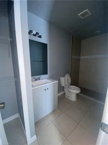 Bathroom with vanity, light tile patterned floors, and a tile shower
