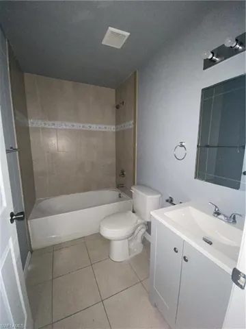 Full bathroom with vanity, tub / shower combination, and light tile patterned floors