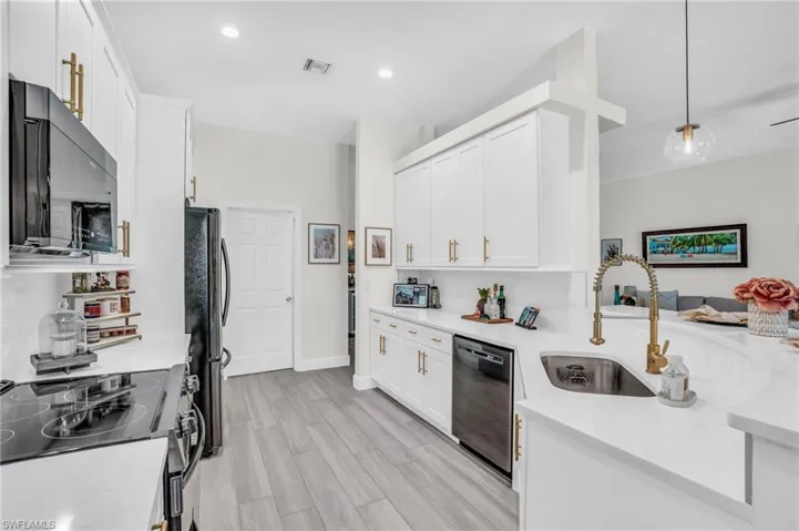 Kitchen featuring white cabinetry, tasteful backsplash, dishwasher, electric range oven, and sink