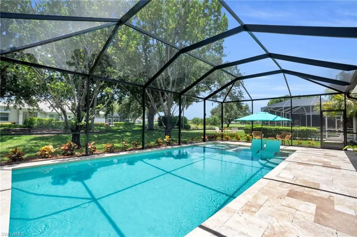 View of swimming pool featuring a lawn, a patio area, and a lanai