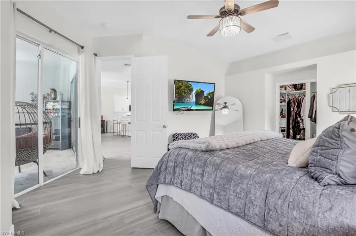 Bedroom with a closet, hardwood / wood-style flooring, ceiling fan, a walk in closet, and access to outside