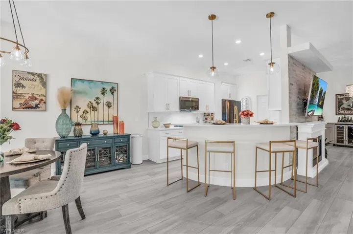 Kitchen with white cabinets, light hardwood / wood-style floors, and appliances with stainless steel finishes
