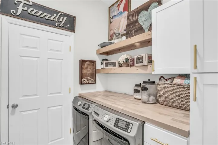 Kitchen featuring wooden counters, white cabinetry, and separate washer and dryer