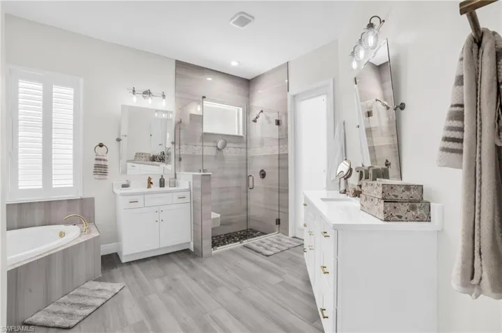 Bathroom with plus walk in shower, wood-type flooring, and double sink vanity
