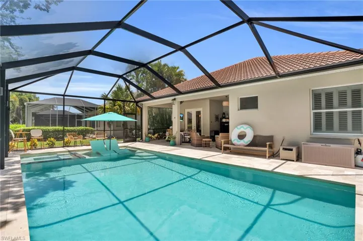 View of swimming pool with a patio and glass enclosure