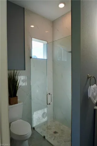Bathroom featuring a marble finish shower, recessed lighting, and tile patterned flooring