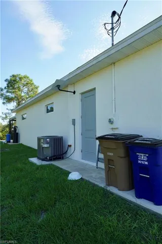 Back of property featuring stucco siding and a yard