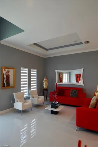 Tiled living room with a tray ceiling and ornamental molding