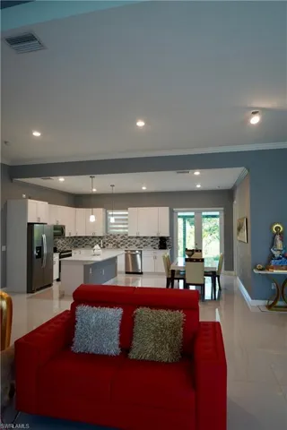 Living room with recessed lighting, crown molding, healthy amount of natural light, and light tile patterned flooring