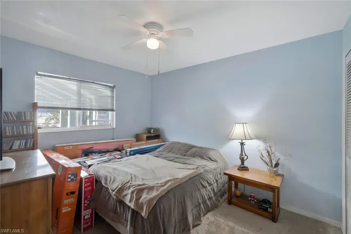 Carpeted bedroom featuring ceiling fan and baseboards