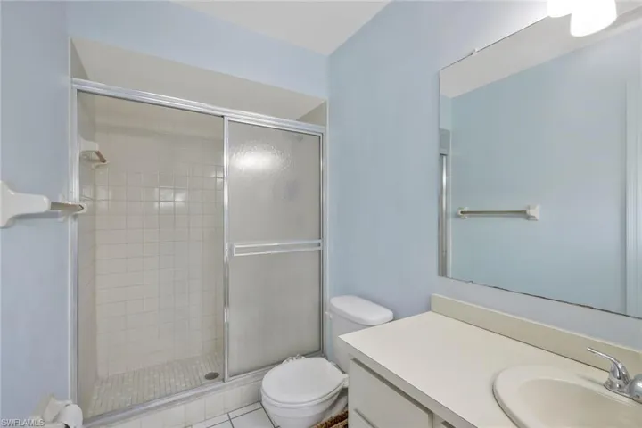 Bathroom featuring toilet, a shower stall, and vanity