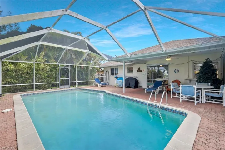 Outdoor pool featuring a lanai, a patio area, ceiling fan, and outdoor dining area