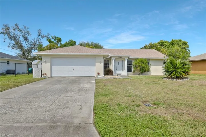 Single story home featuring concrete driveway, an attached garage, fence, a front yard, and stucco siding