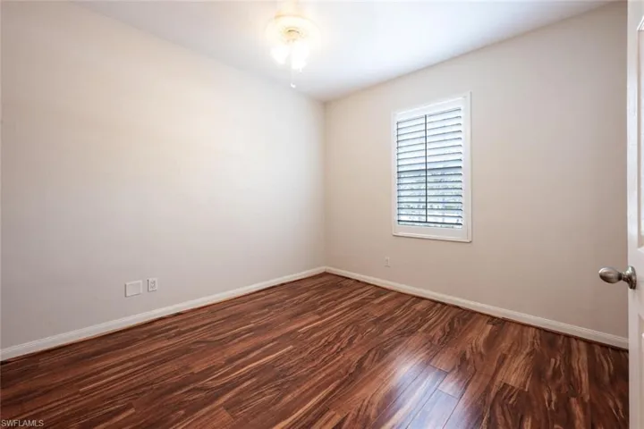 Unfurnished room with dark wood-style flooring and baseboards