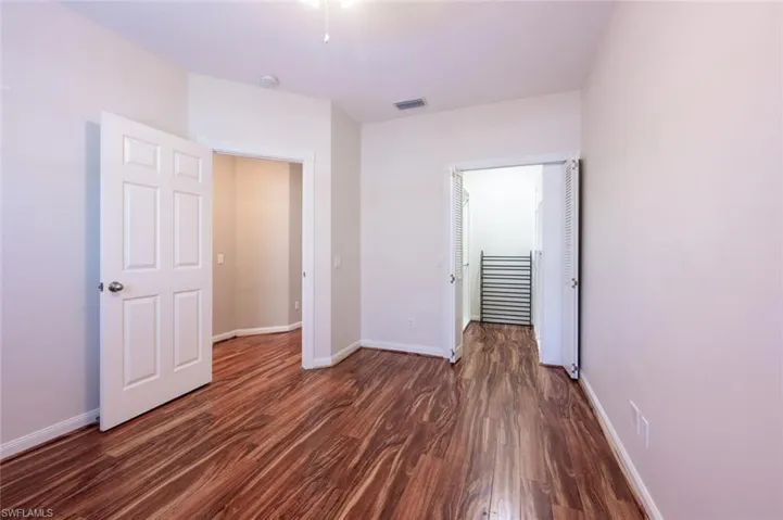 Unfurnished bedroom featuring baseboards, visible vents, and wood finished floors