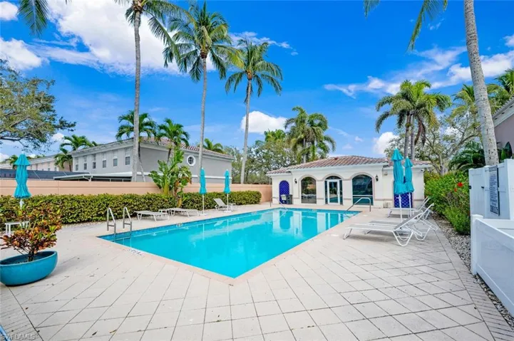 Community pool featuring a patio area and fence