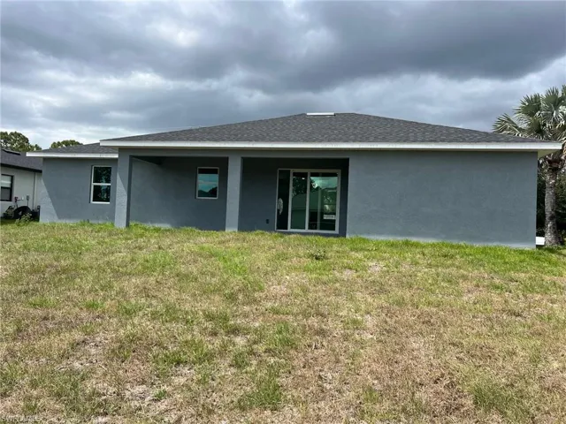 Rear view of property with a lawn