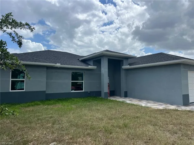 Back of property with a lawn