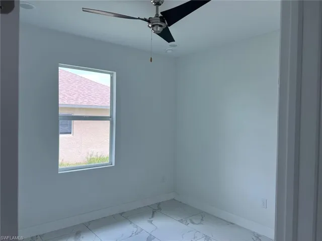 Tiled empty room featuring ceiling fan