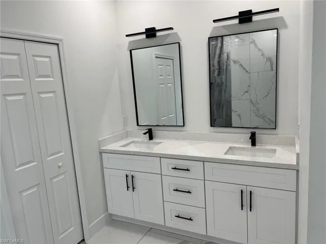 Bathroom featuring double vanity and tile floors