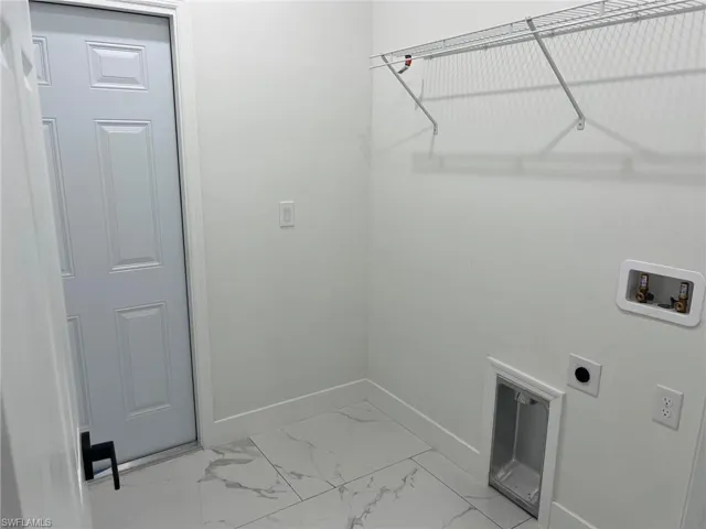 Laundry room with hookup for an electric dryer, light tile floors, and washer hookup