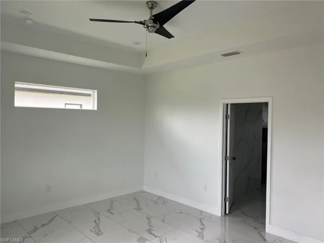 Spare room with ceiling fan and light tile floors
