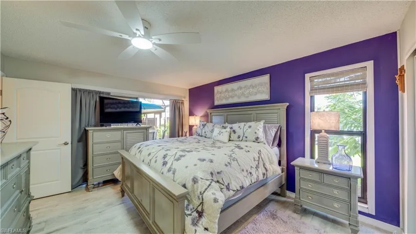 Wood-finish flooring, ceiling fan with integrated lighting, and window with natural light