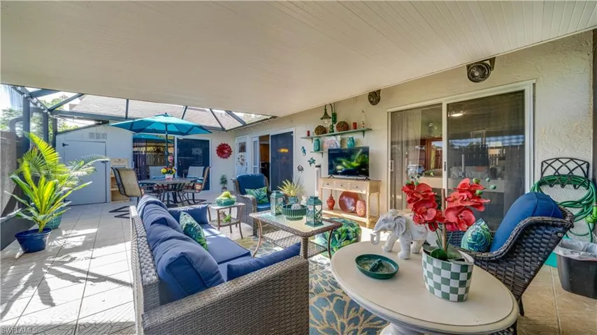 Screened-in covered patio featuring tile flooring, metal frame construction, and sliding glass door access